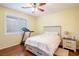 Bedroom with hardwood floors, ceiling fan, plantation shutters and bed with storage drawers at 7611 Redcloud Peak St St, Las Vegas, NV 89166
