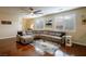 Spacious living room with hardwood floors, large sectional sofa, and bright windows at 7611 Redcloud Peak St St, Las Vegas, NV 89166