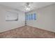 Bright bedroom features modern ceiling fan, neutral carpet, window with shutters, and a built-in bookshelf at 8012 Desire Ave, Las Vegas, NV 89128