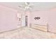 Bedroom with pink walls offers a ceiling fan, mounted TV hardware and modern dresser at 8012 Desire Ave, Las Vegas, NV 89128