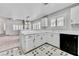 Open kitchen layout features white cabinetry, black appliances, and view into the living space at 8012 Desire Ave, Las Vegas, NV 89128
