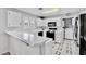 Well-lit kitchen featuring white cabinets, black appliances, breakfast bar, and patterned flooring at 8012 Desire Ave, Las Vegas, NV 89128