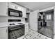 Functional kitchen design features black appliances, white cabinetry, and unique patterned flooring at 8012 Desire Ave, Las Vegas, NV 89128