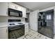 Well-equipped kitchen with black appliances, white cabinetry, and easy access to the refrigerator at 8012 Desire Ave, Las Vegas, NV 89128