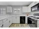 Bright kitchen with white cabinets, black appliances, and a window view, creating a functional cooking space at 8012 Desire Ave, Las Vegas, NV 89128