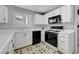 Efficient kitchen with white cabinets, black appliances, and natural light, creating a practical cooking area at 8012 Desire Ave, Las Vegas, NV 89128