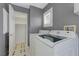 Functional laundry room with modern appliances and storage shelves, offers convenience and organization at 8012 Desire Ave, Las Vegas, NV 89128