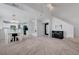 Bright living room featuring neutral carpet, high ceilings, and a cozy fireplace at 8012 Desire Ave, Las Vegas, NV 89128