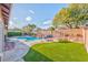 Lush backyard with a sparkling pool, waterfall feature, and mature landscaping creating a private oasis at 8212 Cabin Springs Ave, Las Vegas, NV 89131