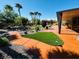 Backyard with artificial turf, covered patio, desert landscaping, and walkway at 8225 Fulton Ranch St, Las Vegas, NV 89131