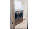Laundry room with gray washer and dryer, white cabinets, sink, and shuttered window at 8225 Fulton Ranch St, Las Vegas, NV 89131
