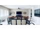 Open-concept living and dining area with a ceiling fan, large windows, and light wood floors at 8225 Fulton Ranch St, Las Vegas, NV 89131