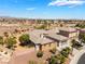 Expansive desert home with a three car garage, lush trees and landscaping and surrounding neighborhood at 8536 Grand Palms Cir, Las Vegas, NV 89131