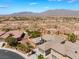 An aerial view showcases the home's tile roof, desert surroundings and mountain views beyond at 8536 Grand Palms Cir, Las Vegas, NV 89131
