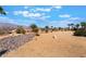 Expansive desert-landscaped backyard with palm trees and mountain views, offering a serene outdoor space at 8536 Grand Palms Cir, Las Vegas, NV 89131