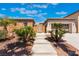 Charming single-story home with stone accents, lush desert landscaping, and a cozy walkway at 8536 Grand Palms Cir, Las Vegas, NV 89131