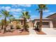 Inviting single-story home with mature palm trees, desert landscaping, and a stone-accented facade at 8536 Grand Palms Cir, Las Vegas, NV 89131