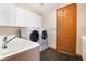 Laundry room complete with washer, dryer, utility sink, and storage cabinets at 8536 Grand Palms Cir, Las Vegas, NV 89131