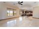 Bright living room featuring sleek tile flooring, a ceiling fan, and large windows overlooking the yard at 8536 Grand Palms Cir, Las Vegas, NV 89131