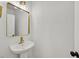 Elegant powder room featuring a pedestal sink, gold fixtures, and a decorative square mirror at 8904 Meisenheimer Ave, Las Vegas, NV 89143