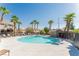Community pool featuring palm trees and ample lounge seating for residents' enjoyment at 10010 Aspen Rose St # 102, Las Vegas, NV 89183