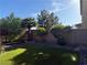 Backyard featuring artificial turf and desert landscaping with a block wall and trees at 109 Delighted Ave, North Las Vegas, NV 89031