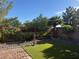 Backyard featuring artificial turf and desert landscaping with a block wall and trees at 109 Delighted Ave, North Las Vegas, NV 89031