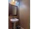 Powder room featuring a pedestal sink, framed mirror, and neutral paint at 109 Delighted Ave, North Las Vegas, NV 89031