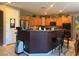 Kitchen with brown cabinetry, tiled flooring and bar seating at 109 Delighted Ave, North Las Vegas, NV 89031