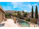 Inviting backyard pool featuring lush landscaping, a small rock waterfall, and great mountain views at 11285 Fiesole St, Las Vegas, NV 89141