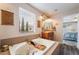Inviting bathroom with a large soaking tub, vanity with wood cabinets, and natural light at 11285 Fiesole St, Las Vegas, NV 89141