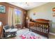 Stylish Bedroom room with neutral walls, crib, chair, and window with backyard views at 11285 Fiesole St, Las Vegas, NV 89141