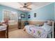 Bright bedroom with a ceiling fan, window, and colorful bedding, perfect for a room at 11285 Fiesole St, Las Vegas, NV 89141