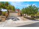 Two-story home featuring a tile roof, a two-car garage, desert landscaping and mature trees at 11285 Fiesole St, Las Vegas, NV 89141