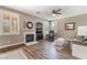 Cozy living room features a fireplace, hardwood floors, plantation shutters, and a ceiling fan at 11285 Fiesole St, Las Vegas, NV 89141