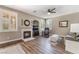 Cozy living room features a fireplace, hardwood floors, plantation shutters, and a ceiling fan at 11285 Fiesole St, Las Vegas, NV 89141