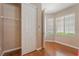 Bright bedroom featuring wood floors, an open closet, and natural light from multiple windows at 11405 Perugino Dr, Las Vegas, NV 89138