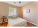 Comfortable bedroom featuring wood floors, a comfortable bed, and natural light from the window at 11405 Perugino Dr, Las Vegas, NV 89138