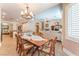 Dining area with wood table, shutters, decorative chandelier, and open to the kitchen at 11405 Perugino Dr, Las Vegas, NV 89138
