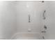 All-white tiled bathtub with a shower featuring safety bars at 11405 Perugino Dr, Las Vegas, NV 89138