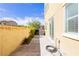 Exterior backyard featuring concrete pavers, a block wall, the side of a home, and green trees at 1185 Via Dimartini, Henderson, NV 89052