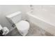 Clean bathroom featuring a white toilet and bathtub combination against gray tiled floor at 1185 Via Dimartini, Henderson, NV 89052