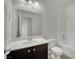 A clean half-bathroom with a modern vanity, toilet, and well-lit mirror at 1185 Via Dimartini, Henderson, NV 89052