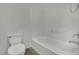 Bright bathroom featuring a white toilet, a bathtub with white tiling, and neutral toned flooring at 1185 Via Dimartini, Henderson, NV 89052