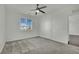 Bright bedroom with a ceiling fan, carpeted floors, and a large window, providing ample natural light at 1185 Via Dimartini, Henderson, NV 89052