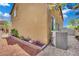Exterior view of tan home, landscaping, and air conditioning unit at 1185 Via Dimartini, Henderson, NV 89052