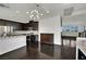 Modern kitchen with stainless appliances, granite counters, dark cabinets, and dark wood flooring at 1185 Via Dimartini, Henderson, NV 89052