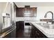Close up view of stainless steel appliances, granite countertops in dark wood kitchen at 1185 Via Dimartini, Henderson, NV 89052