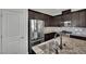Modern kitchen featuring stainless steel appliances, granite countertops, and dark wood cabinets at 1185 Via Dimartini, Henderson, NV 89052