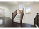 Well-lit staircase with dark wood railing, carpeted stairs, and a door leading outside, enhancing the modern design at 1185 Via Dimartini, Henderson, NV 89052